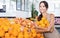 Happy female customer choosing ripe sweet citrus