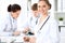 Happy female doctor and medical staff discussing something while sitting at the table