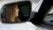 Happy female driver sitting in car and talking with boyfriend, rearview mirror