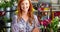 Happy female florist standing with arms crossed in flower shop