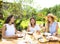 Happy female friends with glasses of lemonade at dining table