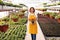 Happy female gardener on path in greenhouse