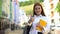 Happy female high-schooler with rucksack and books gesturing thumbs-up, student