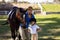 Happy female jockey with sister standing by horse