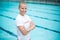 Happy female lifeguard standing at poolside