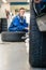 Happy Female Mechanic Changing Car Tire At Automobile Shop