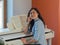 Happy female musician playing piano indoor