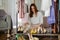 Happy female putting shoes and clothes on shelf at dressing room. Organization storage of clothing