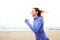 Happy female runner on beach with hair blowing