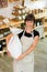 Happy female shopkeeper holding a flour bag in her arms.