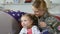 Happy female soldier and cute daughter national flag watching parade together