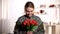 Happy female soldier in uniform sniffing aroma of tulips bouquet and smiling