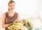 Happy Female Store Owner Holding Sheets In Bedding Store