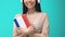 Happy female student headphones holding French book, online seminar, knowledge