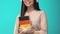 Happy female student headphones holding German book, online seminar, knowledge