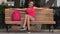 Happy Female Student Relaxing And Resting On Park Bench