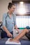 Happy female therapist looking away while scanning feet of boy