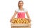 Happy female vendor holding a crate full of pears