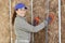 happy female worker applying mineral wool insulation
