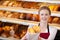 Happy Female Worker Giving Bag Of Breads