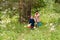 Happy fifty-year-old grandmother and grandson walking in the woods in the summer. hike in the forest