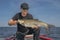 Happy fisherman with big asp fish aspius trophy at the boat with fishing tackles