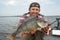 Happy fisherman with big perch fish trophy at boat