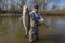 Happy fisherman with zander fish. Success walleye fishing at wild river