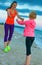 Happy fit mother and child on seashore in evening workout