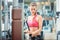 Happy fit woman wearing pink fitness bra while exercising at the gym