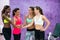 Happy fit women putting hands together before group workout clas