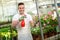 Happy florest watering flower in glasshouse