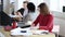 Happy focused business woman in red dress very busy with paperwork, writing on documents at modern office table.