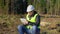 Happy forest engineer with tablet PC in the forest