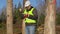 Happy Forest engineer with tablet PC near the trees