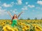 Happy free Asian woman dancing with arms up of hapiness in sunflowers field celebrating spring relaxing in the sun. Girl