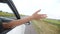 Happy free girl put her hand out and in the car window. concept travel road hand out of the window. the girl touches the