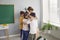 Happy friendly children together hug teacher woman after end of lessons elementary school