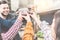 Happy friends cheering with recycle glasses of wine at barbecue dinner - Young people drinking at bbq party in garden backyard -