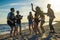 Happy friends dancing on the beach. Men is playing guitar