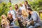 Happy friends having fun outdoor - Young people drinking red wine at winery vineyard