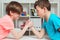 Happy friends playing arm wrestle looking at each other. Cute brothers spending time together at home