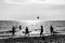 Happy friends playing football on the beach at sunset - Silhouettes of teen friends playing beach soccer during summer holidays -