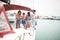 Happy friends sailing on boat - vacation, travel, friendship and people concept