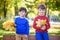 Happy friends, schoolchildren having fun in autumn park among fallen leaves