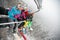 Happy friends skiers and snowboarders on ski lift for skiing in