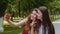 Happy friends taking selfie with the smartphone in the park