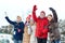 Happy friends waving hands on ice rink outdoors