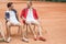 happy friends with wooden rackets sitting on chairs