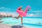 Happy fun luxury hotel vacation woman jumping of joy taking selfie with pink inflatable swimming pool mattress at